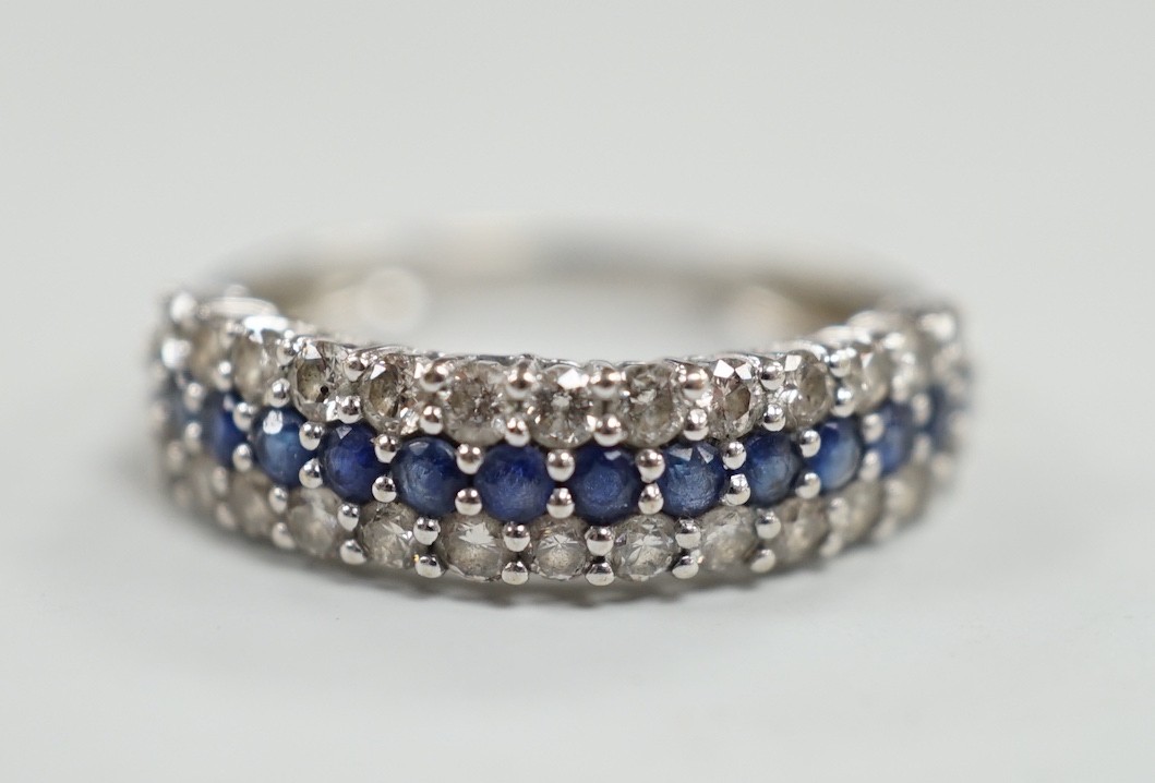 A modern 750 white metal, sapphire and diamond set three row half hoop ring, size M, gross weight 2.5 grams.